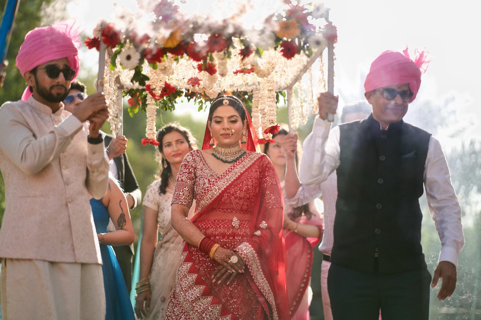Aagman: Held up by family, framed by flowers.