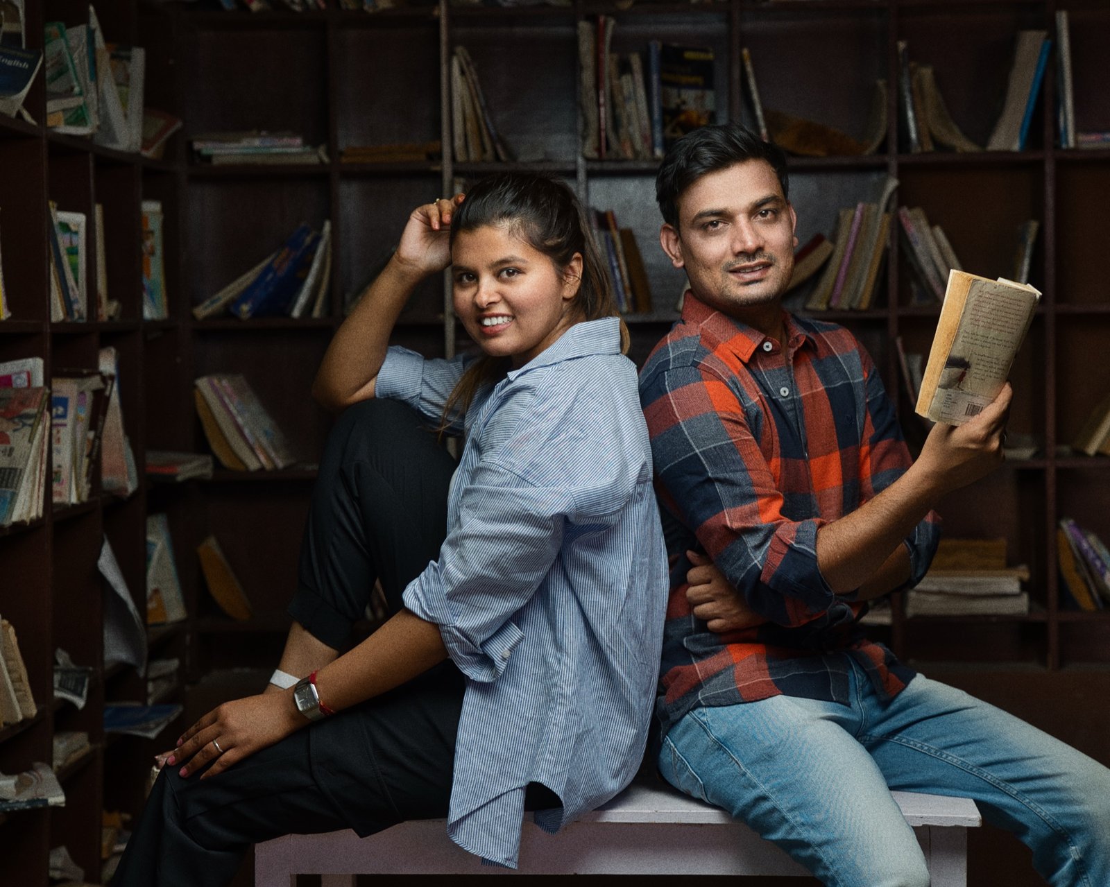 Just Us: Back to back among the bookshelves, a story open in hand.